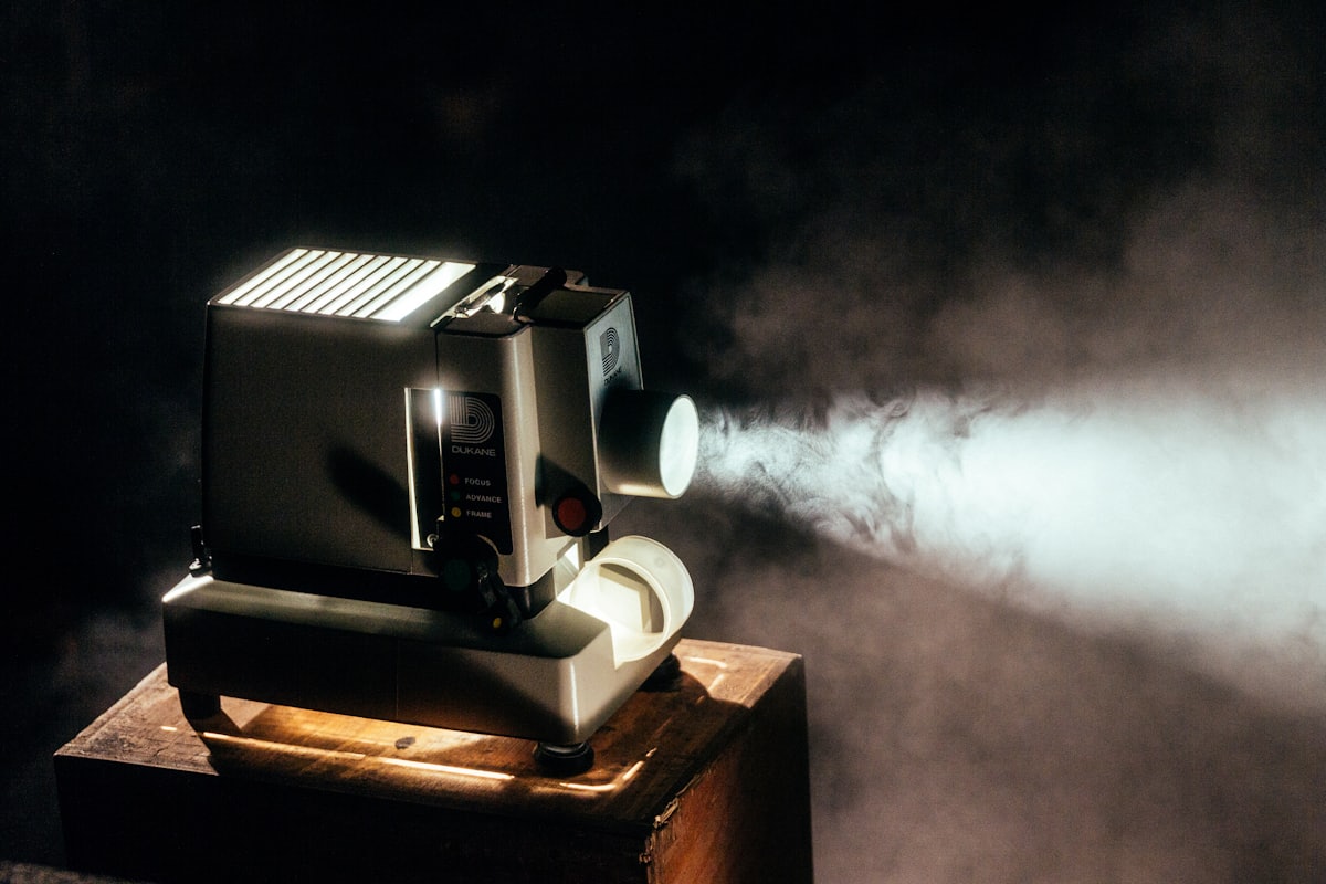 A film projector cutting a beam through the dark of our lighting studio