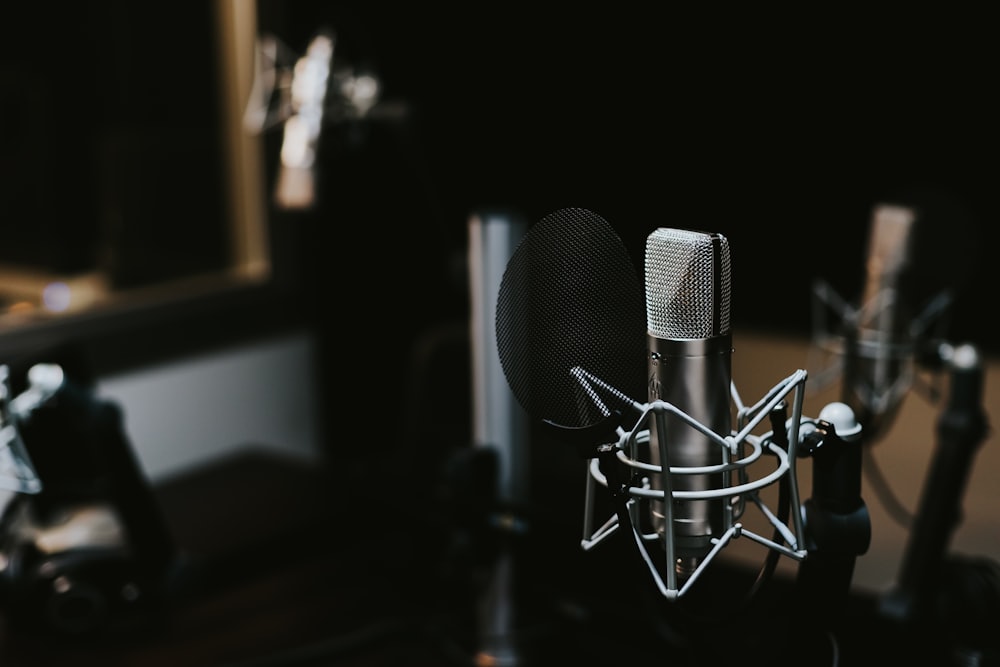 A studio condenser microphone in a darkened booth
